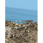 Bracelet jonc doré quadruple fils sur fond blanc, détails cœurs et strass lumineux, bijou ouvert élégant pour le poignet.