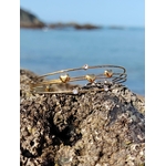 Bracelet doré à jonc ouvert sur décor doux, quatre fils fins avec cœurs et éclats de strass, style bohème chic.