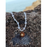 Collier Soleil Pierre de Lune sur roche en Bretagne, perles naturelles aux reflets nacrés et pendentif en acier inoxydable doré.