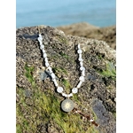 Gros plan sur collier Pierre de Lune avec soleil doré, perles nacrées et acier inoxydable, bijou féminin et solaire.