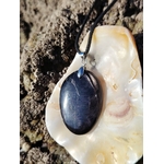 Pendentif Hyperstène sur coquillage en Bretagne avec cordon noir, pierre sombre à reflets doux, introspection et équilibre émotionnel