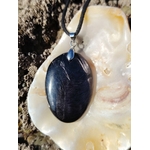 Pendentif Hyperstène ovale sur coquillage clair en Bretagne, pierre noire polie à reflets métallisés, calme mental et protection douce