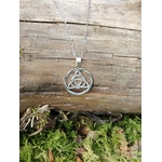 Pendentif Triquetra rond en argent 925 sur décor naturel en Bretagne, bijou celtique ajouré au motif entrelacé.