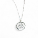 Pendentif Triquetra rond en argent 925 sur fond blanc, détail du symbole celtique ajouré et finition argentée.