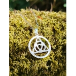 Pendentif Triquetra en argent 925 sur fond minéral en Bretagne, bijou ajouré inspiré des traditions celtiques et de la protection.