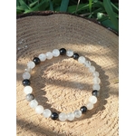 Bracelet Tourmaline noire et Quartz tourmaliné posé sur coupe de bois, perles translucides à inclusions noires pour stabilité et apaisement.
