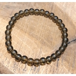 Bracelet en Quartz fumé posé sur bois clair, perles naturelles brun fumé lumineuses, stabilité intérieure et protection énergétique.