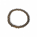 Gros plan sur bracelet Quartz fumé 6 mm sur fond blanc, perles rondes brun clair à brun profond, bijou sobre associé à l’équilibre.