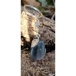 Porte-clés ou bijou de sac Fluorite sur décor naturel, attache argentée et pierre polie aux reflets verts, bleus et violets.