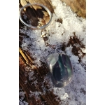 Gros plan sur porte-clés Fluorite multicolore, pierre polie aux nuances vertes et violettes sur fond naturel.