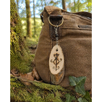 Bijou de sac Sigile de Protection Physique accroché à un sac brun en forêt, avec bois gravé et Tourmaline noire d’ancrage.