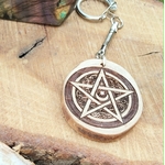 Accessoire de sac ou bijou de sac en bois gravé pentacle, détail du symbole spirituel avec attache métallique pour une touche mystique discrète.