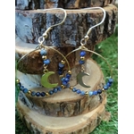 Créoles pendantes dorées en lapis lazuli facetté, détails bleus profonds et lune centrale pour sagesse et équilibre énergétique.
