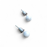 Boucles d’oreilles puces Howlite blanche veinée sur fond blanc, perles 6 mm en acier inoxydable argenté pour calme et équilibre émotionnel.
