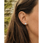 Boucle d’oreille puce Howlite 6 mm portée en situation naturelle, pierre blanche veinée sur acier argenté pour douceur et recentrage.