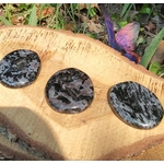 Galet gabbro merlinite mystique tenu en main, pierre polie profonde pour méditation, ancrage et écoute de l’intuition.