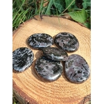 Galets gabbro merlinite mystique polis sur rondin de bois, nuances noires grises blanches et rosées pour ancrage et intuition.