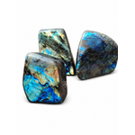 Forme libre labradorite polie aux éclats bleu vert, sur fond blanc pierre naturelle de Madagascar pour équilibre et clarté intérieure.
