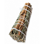 Fagot rituel sauge blanche, cèdre et cannelle sur fond blanc, feuilles argentées et bâton épicé visibles pour purification symbolique.