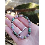 Bracelet équilibre émotionnel tenu en main dans un décor naturel, perles 6 mm pour apaisement du cœur et harmonie intérieure.