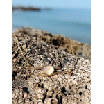 Collier cœur doré rose sur rocher côtier avec mer floutée, pendentif délicat pour amour, douceur et cadeau symbolique.