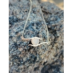 Collier cœur en acier inoxydable doré posé sur roche brute, pendentif clair au centre pour amour de soi et douceur au quotidien.
