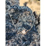Collier cœur rose gold présenté sur roche sombre, bijou fin en acier inoxydable pour attention tendre et style lumineux.