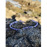 Bracelet améthyste facettée 3 mm posé sur roche en bord de mer, cuivre plaqué or pour apaisement et élégance violette.
