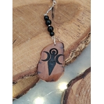 Bijou de rétroviseur en bois face Gaïa sur décor de bois brut, tourmaline noire et chaîne argentée pour une touche mystique.