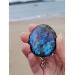 Galet de labradorite dans la main, pierre polie aux éclats bleutés pour apaisement et équilibre énergétique.