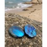 Deux galets de labradorite polie en décor naturel, reflets bleus et turquoise pour intuition, clarté et protection symbolique.