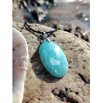 Pendentif Amazonite porté au cou, bijou bleu-vert sur tenue blanche pour communication sincère et clarté intérieure.