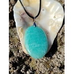 Pendentif Amazonite du Pérou posé sur coquillage en bord de mer, pierre bleu-vert pour douceur et apaisement émotionnel.
