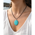 Pendentif Amazonite ovale porté au cou sur vêtement blanc, pierre naturelle du Pérou pour authenticité, douceur du cœur et fluidité intérieure.