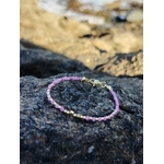 Bracelet en Tourmaline rose facettée sur roche côtière, éclats dorés et perles roses pour équilibre affectif.