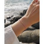 Bracelet Tourmaline rose porté au poignet face à la mer, bijou fin en cuivre plaqué or pour tendresse intérieure.