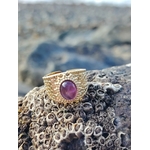 Bague dorée ajustable Améthyste sur roche de bord de mer en Bretagne, acier inoxydable texturé et pierre violette lumineuse.