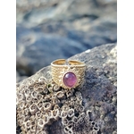 Bague acier inoxydable doré avec Améthyste posée sur roche côtière bretonne, pierre violette pour calme et sérénité.