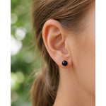 Boucle d’oreille puce Obsidienne noire 6 mm portée à l’oreille, bijou discret en inox 304 pour stabilité et force intérieure.