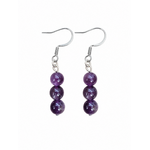 Paire de boucles pendantes Améthyste Magic Gaïa sur fond blanc, perles mauves alignées et crochets inox, pour calme et clarté intérieure.