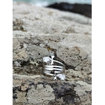 Bague argentée Ankh stylisée posée sur roche en Bretagne, acier inoxydable et strass goutte pour renouveau et protection.
