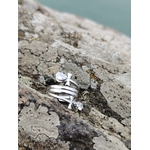 Bague croix de vie stylisée en acier inoxydable sur rocher, mer floutée en arrière-plan et strass goutte lumineux.