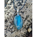 Pendentif Labradorite bleue sur roche à coquillages en Bretagne, cordon noir et reflet cyan pour bouclier énergétique.