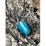 Pendentif Labradorite bleue posé sur rocher marin en Bretagne, reflets turquoise pour calme intérieur et intuition.