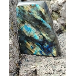 Forme libre Labradorite entre roches marines en Bretagne, jeux bleu or et vert pour protection subtile et discernement.