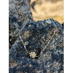 Bracelet Améthyste feuille dorée sur rocher sombre en bord de mer breton, chaîne fine en acier inoxydable et perles violettes pour sérénité, intuition et équilibre émotionnel.