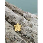 Bague fleur dorée réglable posée sur rocher côtier, bijou floral en acier inoxydable finition or 18K au rendu délicat et estival.