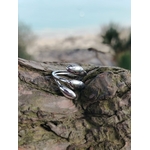Bague argentée ajustable triple goutte en acier inoxydable sur écorce, bijou brillant au design moderne et sculptural.