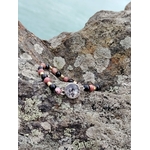 Gros plan sur bracelet Rhodonite Tourmaline Noire, perles naturelles roses et noires, détails dorés et cabochon argenté.