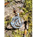 Pendentif Triquetra Lune argent 925 sur écorce et mousse, symbole celtique ajouré avec croissant lunaire.